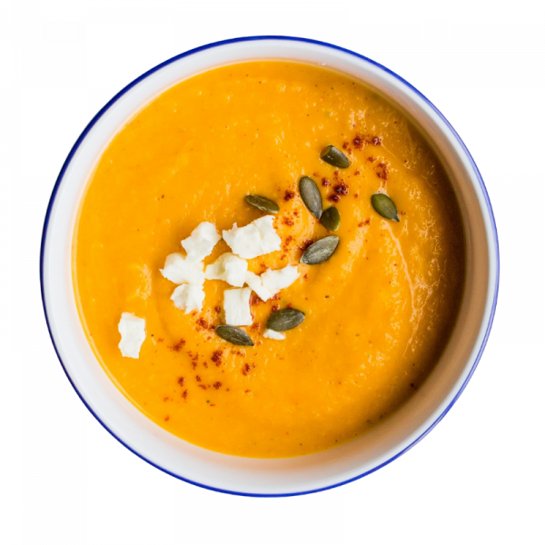 a bowl of sweet potato cream soup sprinkled with pumpkin seeds and feta